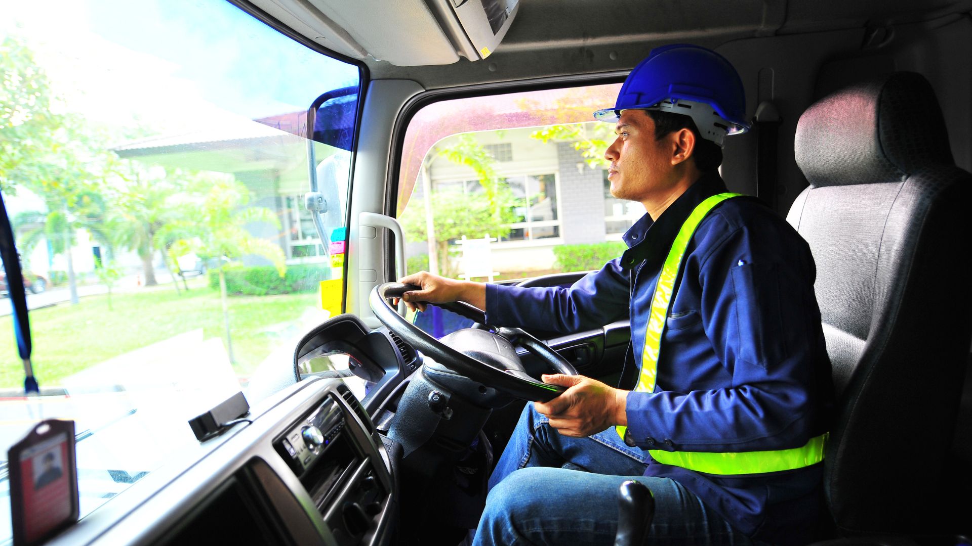 Man driving truck while wearing safety helmet and vest | Fleet Management | Visual Planning
